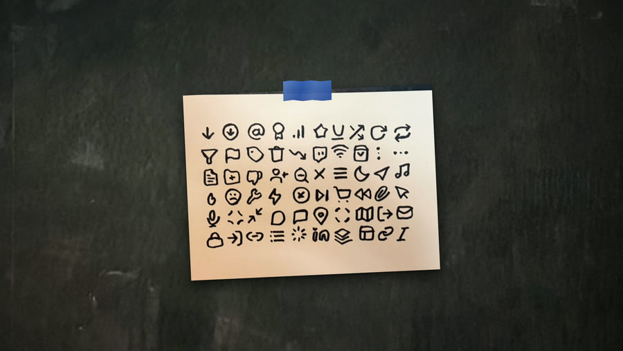 A sheet of hand-drawn icons taped to a chalk wall with blue tape